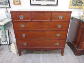A Regency mahogany chest of three over three drawers with embossed oval plate handles, shaped apron,