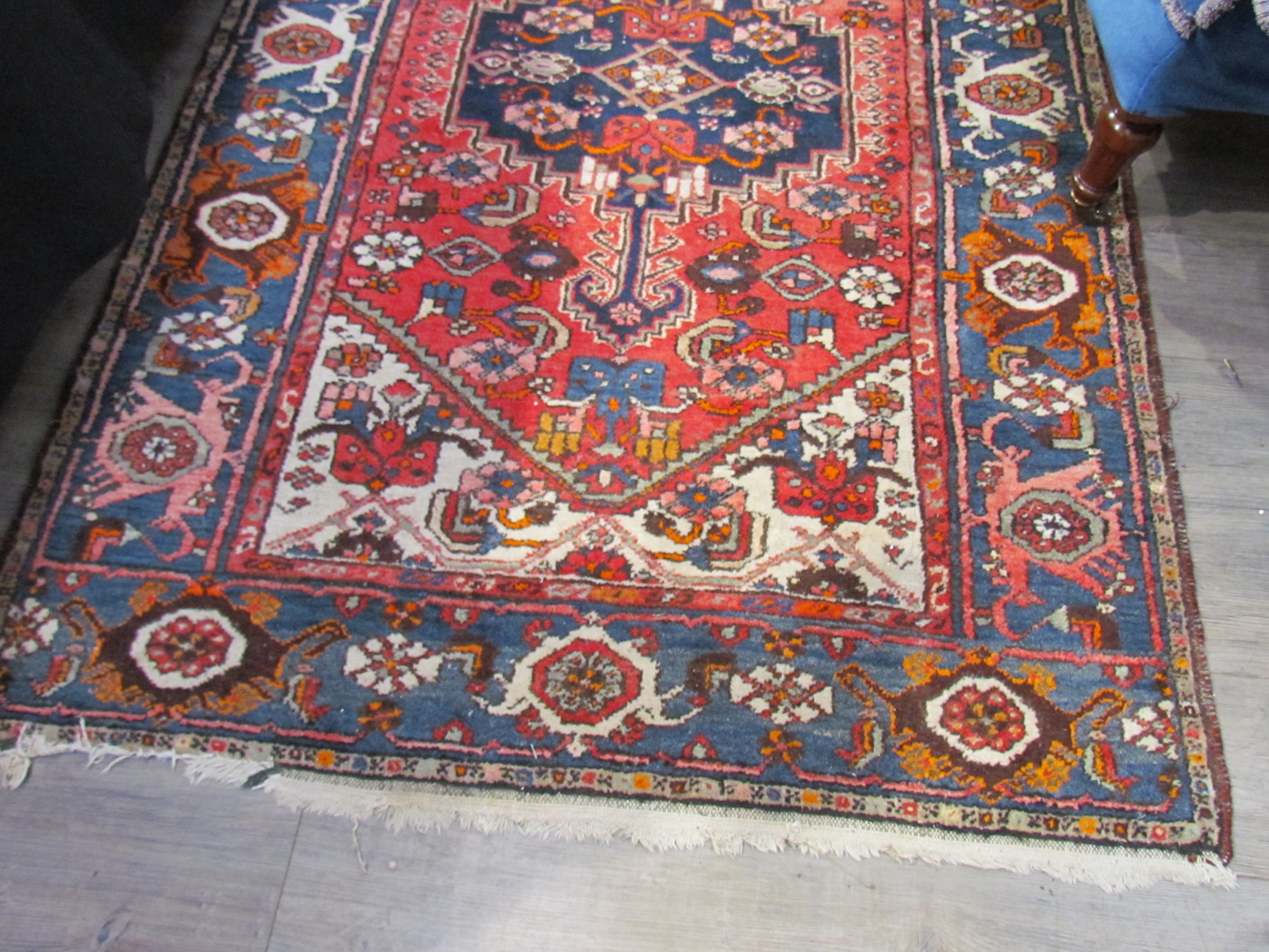A Persian hand knotted rug, red ground with navy foliate border, 200cm x 132cm - Image 4 of 5