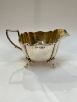 A Charles Westwood and Sons silver jug, raised on four feet, Birmingham 1907, 157g
