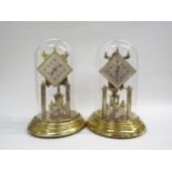 A near identical pair of brass anniversary clocks under glass dome, one marked Koma to back. Both