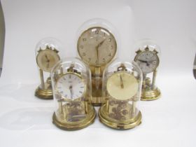 Five brass anniversary clocks under glass domes including Junghans ATO electric and Kundo