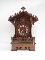 A Black Forest mantle cuckoo clock with key and pendulum, (a/f). 49cm tall