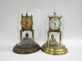 Two brass anniversary clocks under glass and plastic domes. One with enamel white dial with Arabic