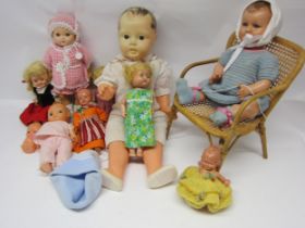 A collection of mid 20th Century plastic and celluloid dolls and a wicker doll chair