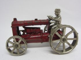 A red painted cast iron tractor with polished metal wheels and driver, in the manner of Arcade, 16.
