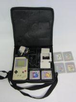 A Nintendo Gameboy handeheld computer games console with power adapter, Gamester power pack, Nuby