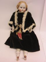 A mid 19th Century German Parian shoulder head doll with moulded blonde hair, striated blue glass