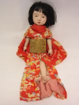 A mid 20 Century composition Japanese character doll, stuffed cloth body with composition limbs,
