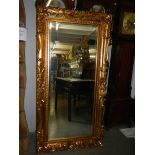 A large rectangular bevel edged mirror in gilded swept frame. 88 x 175 cm.