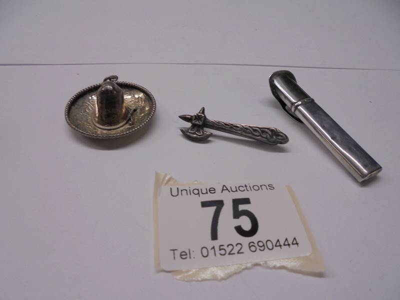 A silver sombrero pendant, a silver axe brooch and a silver button hole holder 10 grams.