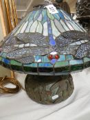 A bronze table lamp with Tiffany style dragon fly shade.