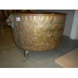 A large embossed brass log bin, 44 cm tall x 62 cm diameter.