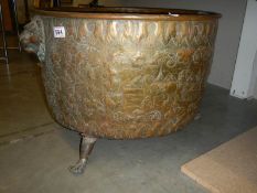 A large embossed brass log bin, 44 cm tall x 62 cm diameter.