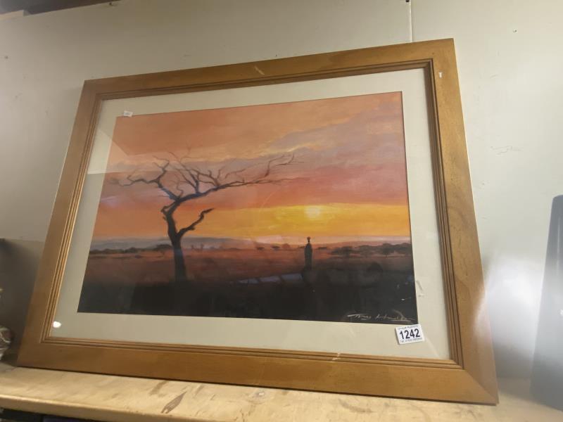 A large framed print of a sunset by Tony Hudson