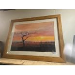 A large framed print of a sunset by Tony Hudson