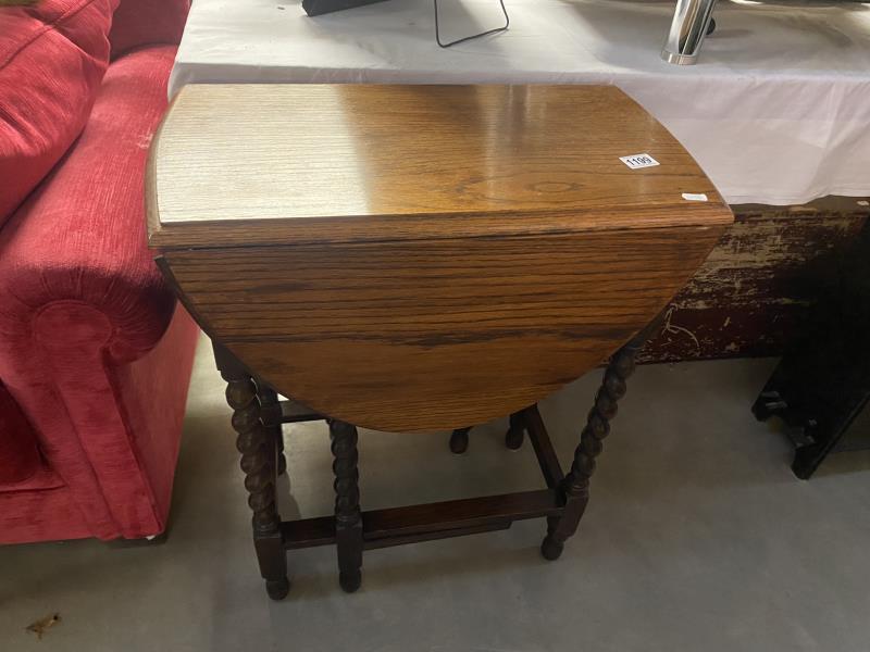 A 1930's oak gateleg table on barley twist legs