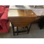 A 1930's oak gateleg table on barley twist legs