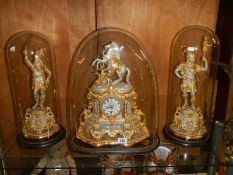 A magnificent French clock garniture under glass domes. The clock surmounted a horse with handler,