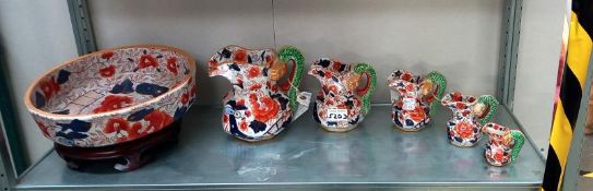 A collection of ironstone Imari dragon handled graduated jugs together with a large Imari bowl on