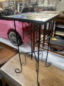 A wrought iron plant stand with floral glass top