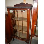 A mahogany single door display cabinet.