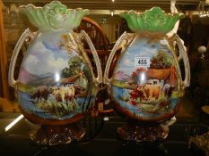 A pair of Staffordshire vases hand painted with cattle.