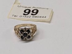 A diamond sapphire cluster ring, hall marked for London 1975, textured shoulders, in 9ct gold,