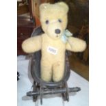 A small vintage style dolls pram with teddy.