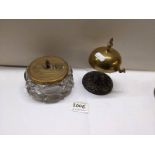 A brass shop bell and a glass inkwell with brass top.
