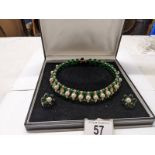 A choker style green stone and pearl necklace with matching earrings.