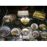 A small collection of souvenir paperweights with various scenes, eleven in total.