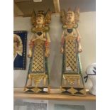 A pair of ornate painted wall carvings of oriental people - 100cm high