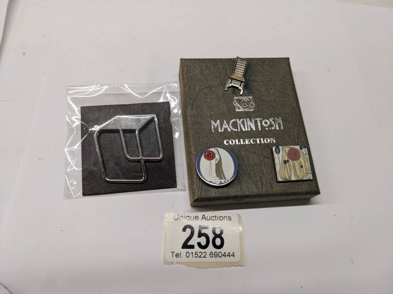 Three enamel Mackintosh collection pin badges and a Marcel Brewer badge of a table.
