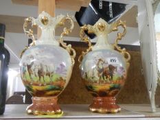 A pair of early 20th century vases decorated with horses.