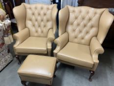 Two large tan leather wingback chairs and a matching foot stool