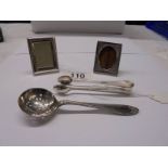 An EPNS sugar sifter spoon, sugar tongs and two miniature photo frames.