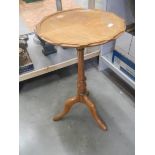 A pale circular tripod table. COLLECT ONLY.