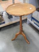 A pale circular tripod table. COLLECT ONLY.