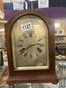 An oak cased clock with silvered dial complete with pendulum and key.