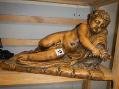 A terracotta cherub lying on a bed of roses signed La Route?