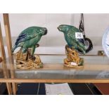 A pair of green ceramic parrots.