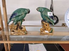 A pair of green ceramic parrots.
