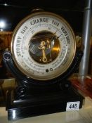 An Edwardian double thermometer/brass cased barometer on carved ebonised plinth.