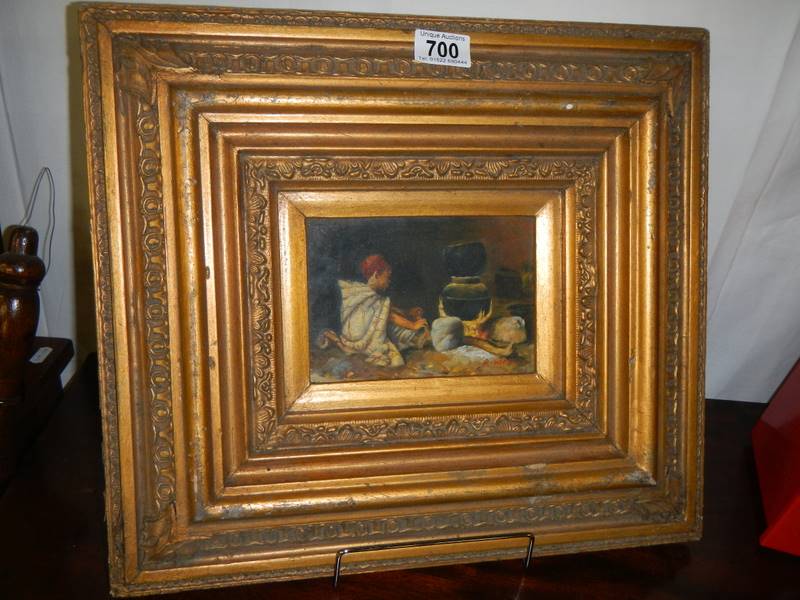 A gilt framed painting on wood.