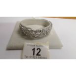 An ornate silver bangle, 22 grams.