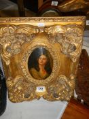 A gilt framed oval portrait of a lady.