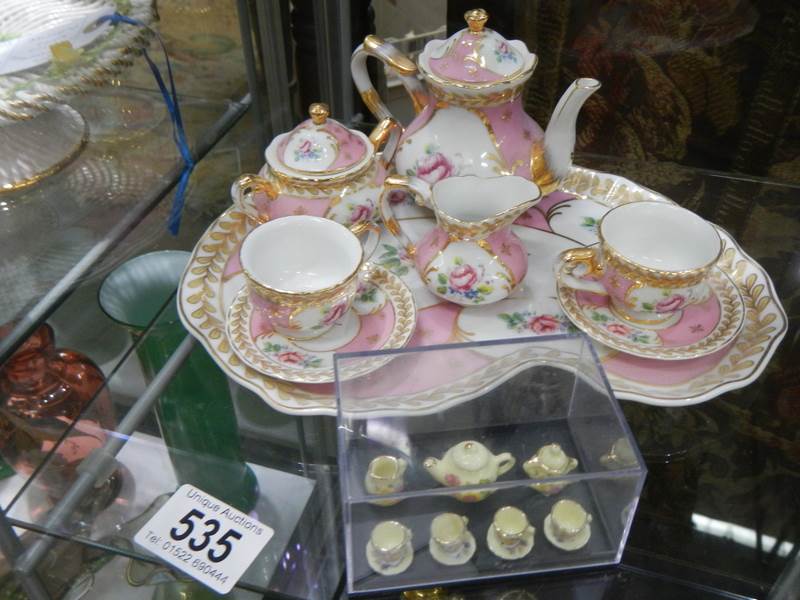 A miniature tea set and one other.