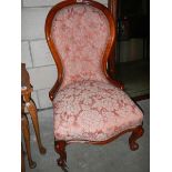 A Victorian mahogany nursing chair on cabriole legs.