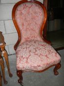 A Victorian mahogany nursing chair on cabriole legs.