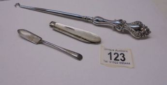 A silver pen knife, a silver jam spoon and a silver handled button hook.